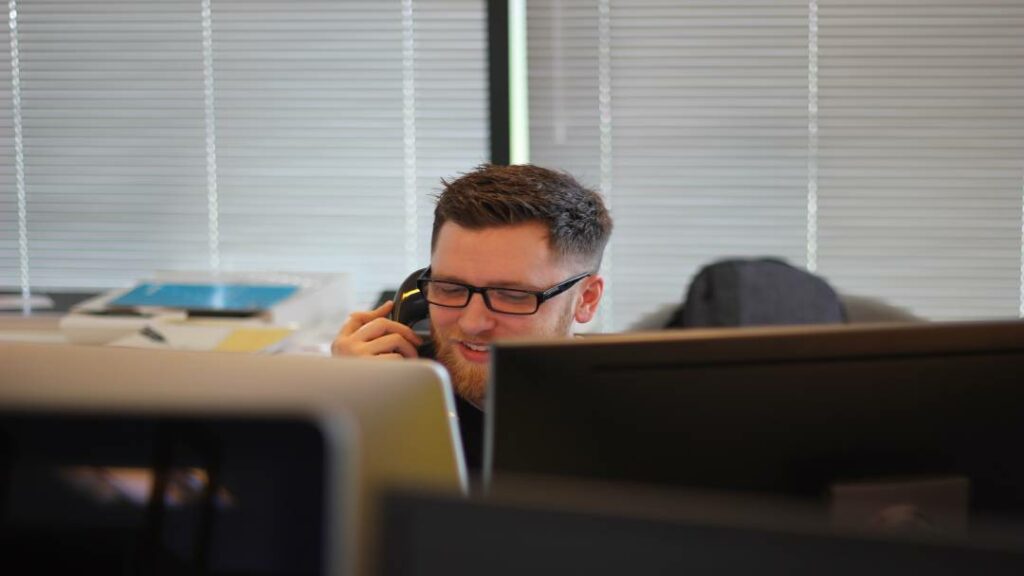 A man talking on a VoIP desk phone