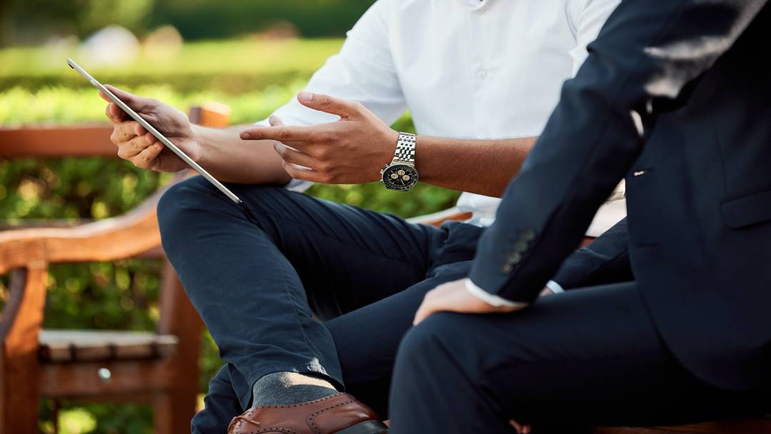 Two men viewing VoIP service providers on a tablet