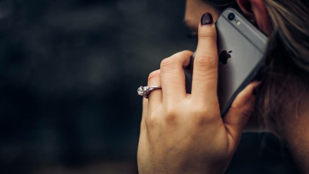 A woman using a VoIP app on her smartphone to make a business call