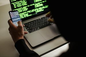 a man working using laptop and phone