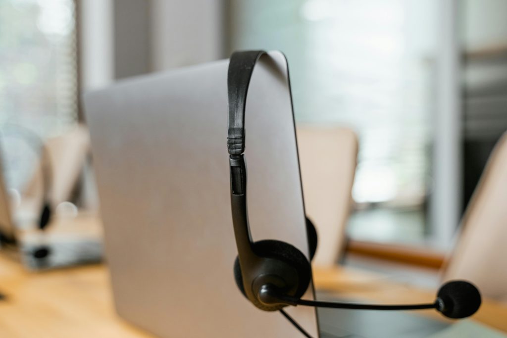 Close-up of a headset on a computer screen in a modern office, representing a business phone system powered by a VoIP white label solution.