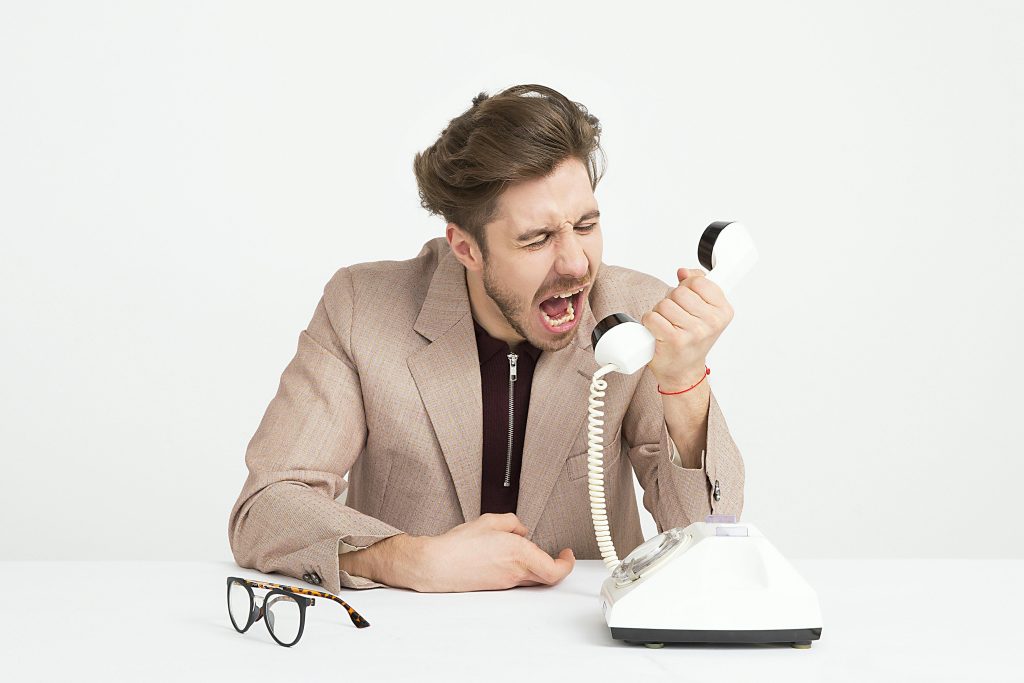 Frustrated user dealing with legacy telecom, like Avaya — a problem solved by a white label VoIP provider