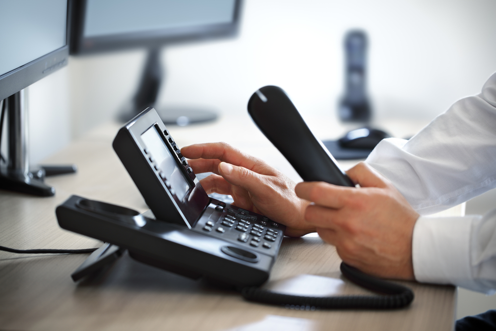 Business professional managing VoIP phone settings—highlighting telecom expense management for Canadian businesses.