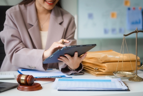 Attorney using a gavel and laptop in a legal office, showing how voip for law firms improves workflow and client responsiveness.