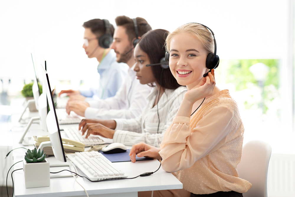 Customer service representatives using headsets in a modern office, representing reliable communication through a VoIP business phone system Oakville.