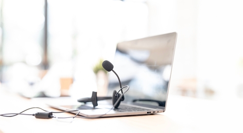 Close-up of a laptop and headset on a desk symbolizing professional business communication from a voip solutions provider in brampton and trusted voip canada provider.