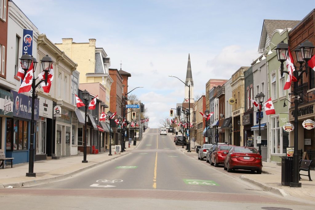 Main Street Newmarket lined with Canadian flags, representing the local community served by the best VoIP providers in Newmarket