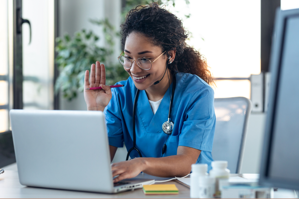 Healthcare professional using VoIP for healthcare to manage patient calls and virtual appointments in a modern medical office