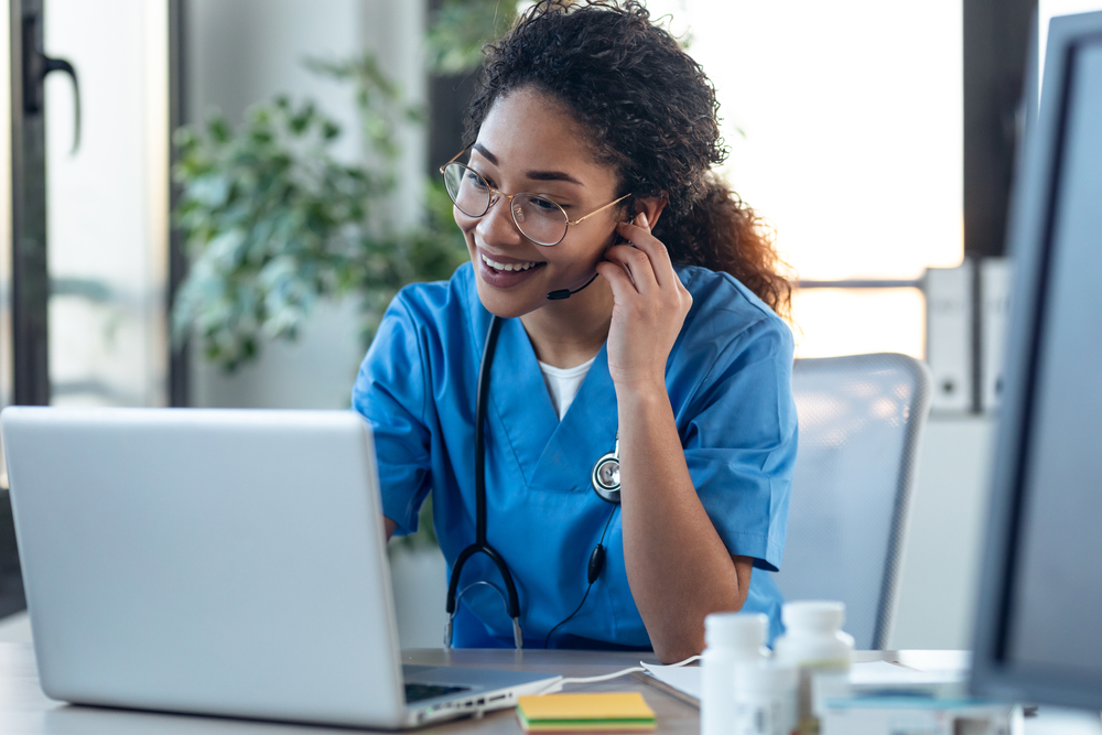 Medical staff member using VoIP for healthcare to manage patient communication and remote support through a cloud phone system