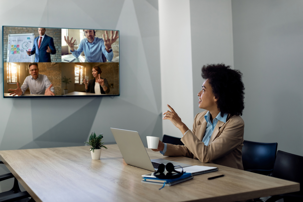 Business professional on a laptop speaking with remote colleagues during a video meeting using voip texas cloud communication tools