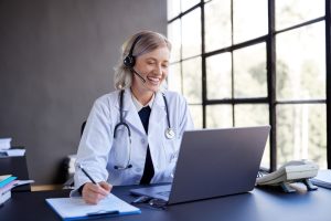 SE Telecom cloud phone systems for healthcare physician using headset and laptop for patient communication in a modern medical office