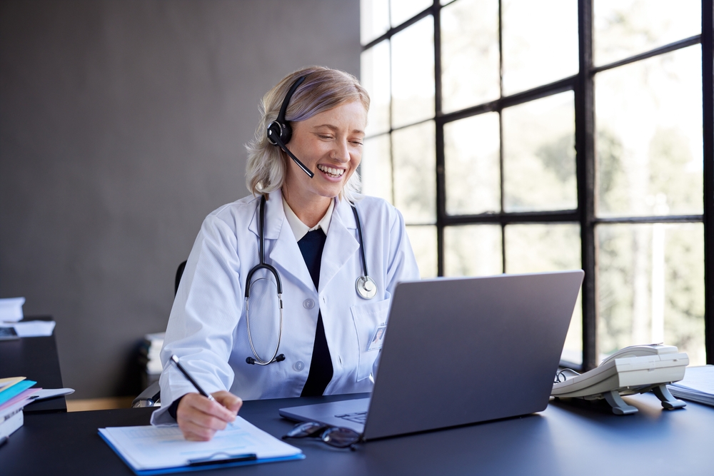 SE Telecom cloud phone systems for healthcare physician using headset and laptop for patient communication in a modern medical office