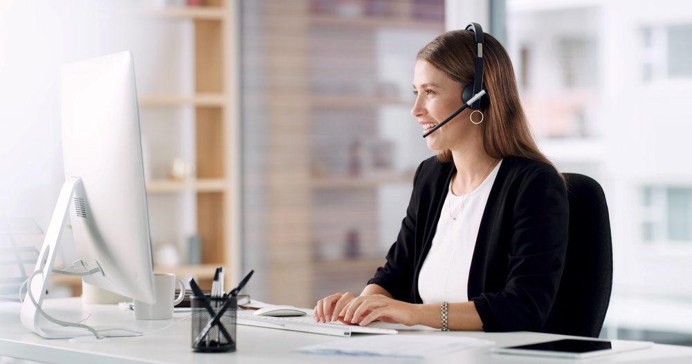 SE Telecom business VoIP services in Vancouver professional using cloud phone system at her desk in a modern BC office