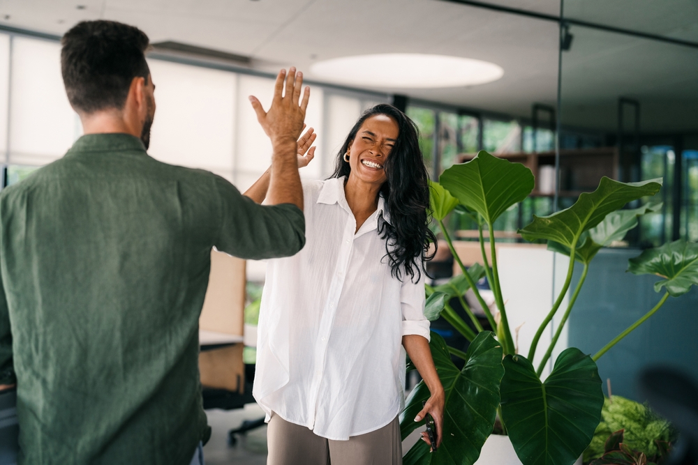 Canadian business professionals high-fiving after successfully evaluating telecom companies in Canada and choosing SE Telecom for their organization
