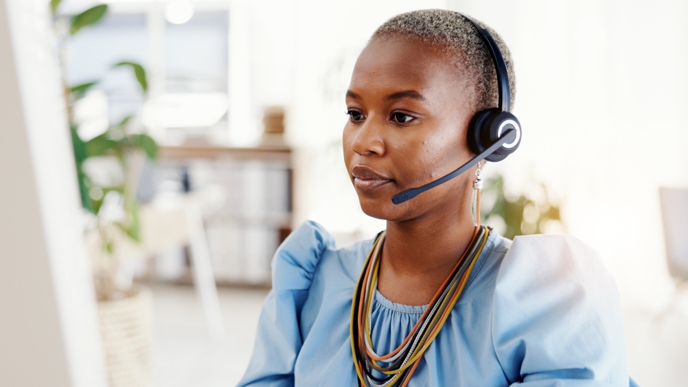 Canadian operations professional using SE Telecom's cloud VoIP platform at her desk in a modern office