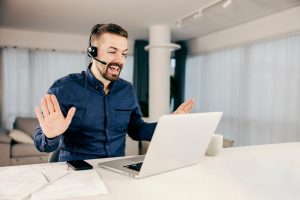 Canadian professional excited about switching to a VoIP telephone system through SE Telecom on a softphone call in his home office