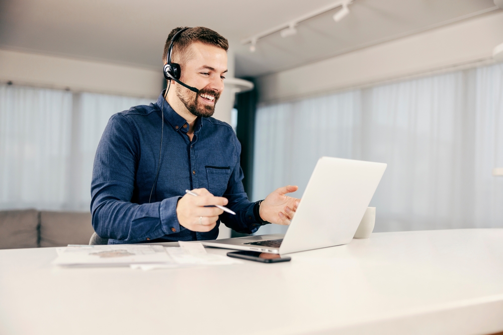 Canadian decision-maker reviewing SE Telecom VoIP telephone deployment options on laptop with headset in a modern workspace