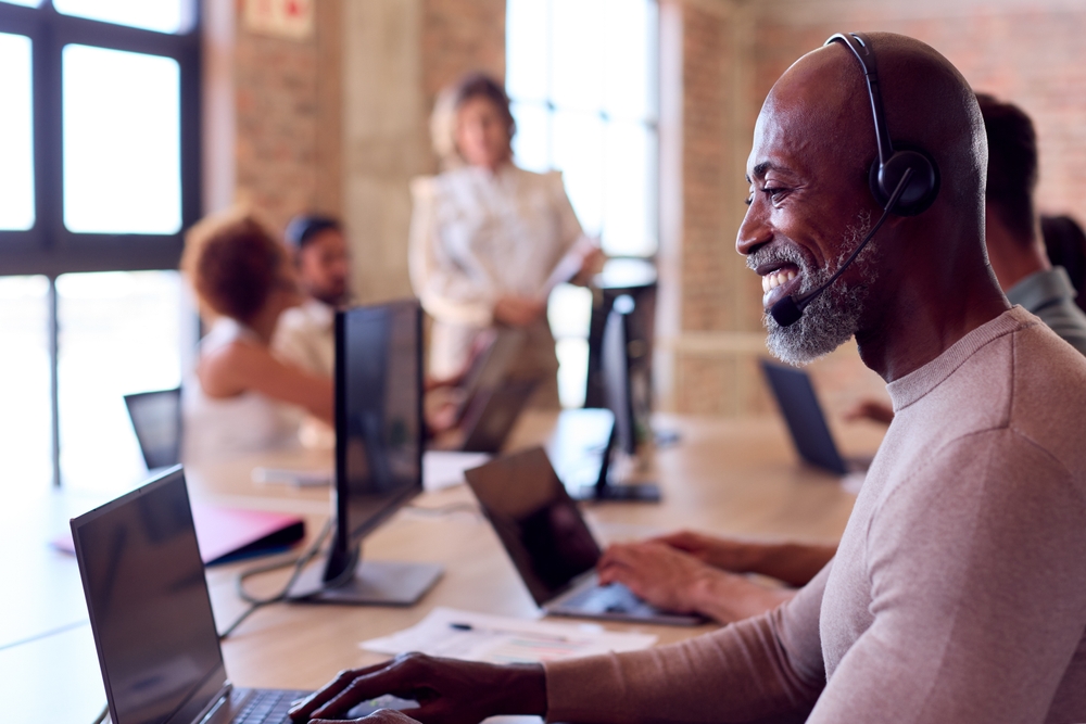 SE Telecom VoIP Winnipeg client manager smiling confidently on headset after successful Manitoba organization cloud phone migration