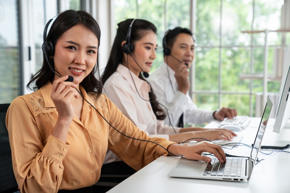 SE Telecom VoIP phone Winnipeg team smiling on headsets managing cloud communication deployments for Manitoba organizations