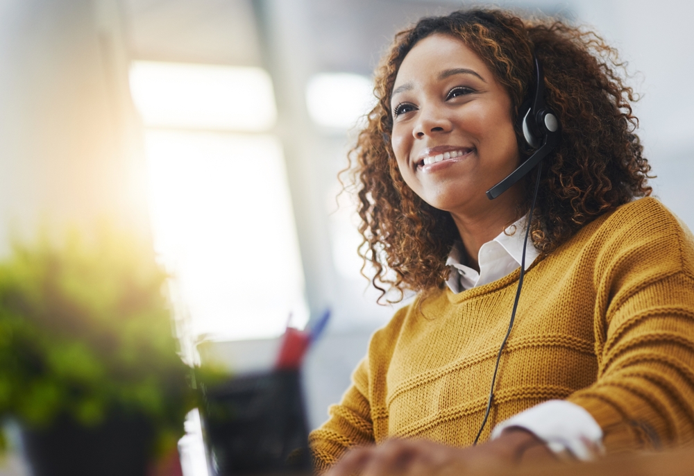 Customer service professional wearing a headset while assisting clients using VoIP Halifax for reliable business communication.
