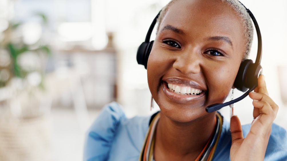 Business professional managing client calls with a headset while using VoIP Halifax for clear and dependable communication.
