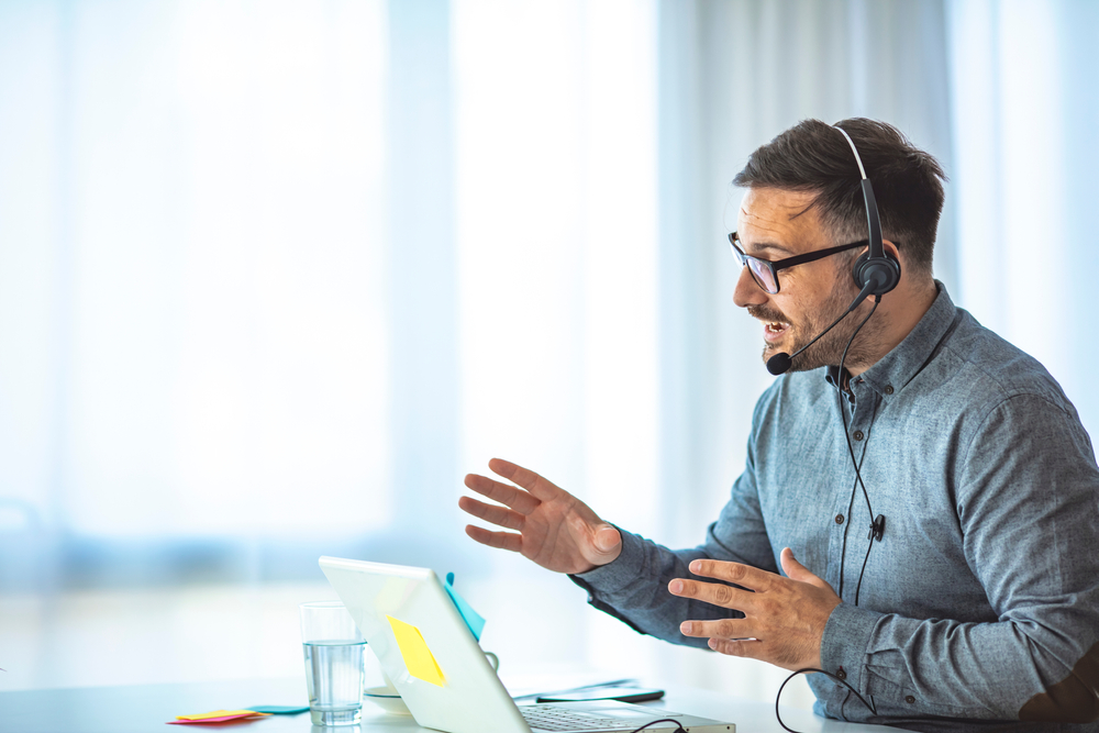 Support representative wearing a headset and providing customer assistance through VoIP Halifax business phone services.
