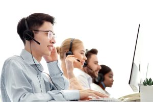 Office worker taking calls and collaborating with colleagues using services from business voip providers for hamilton.