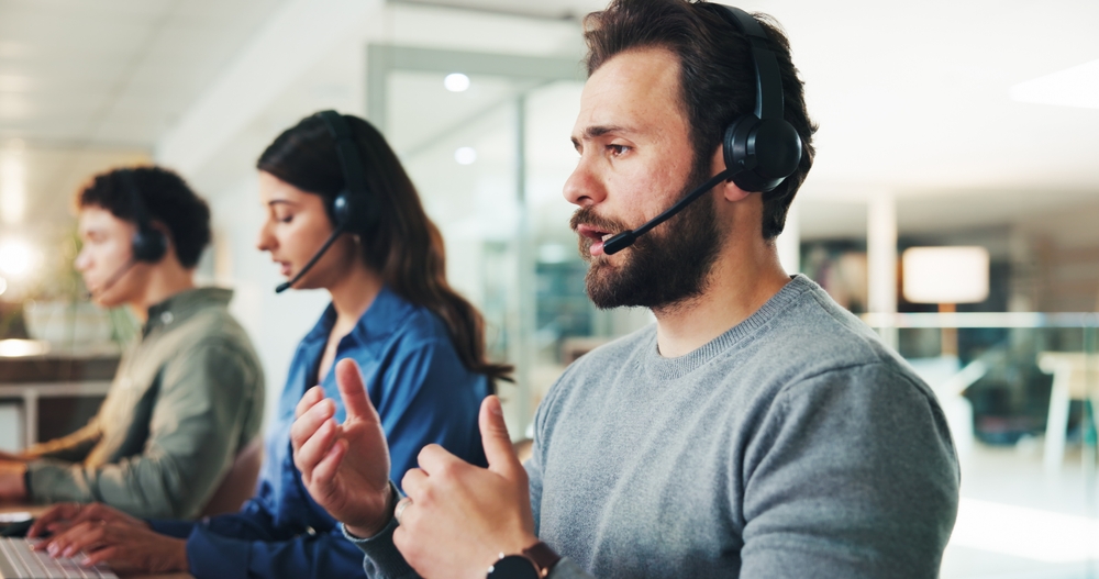 Support representative wearing a phone headset and managing inbound calls with voip london ontario services.