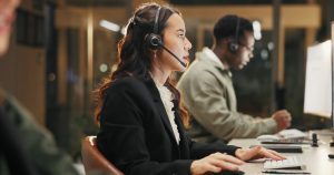 Professional office worker on a headset delivering responsive customer service with voip london ontario business phone solutions.