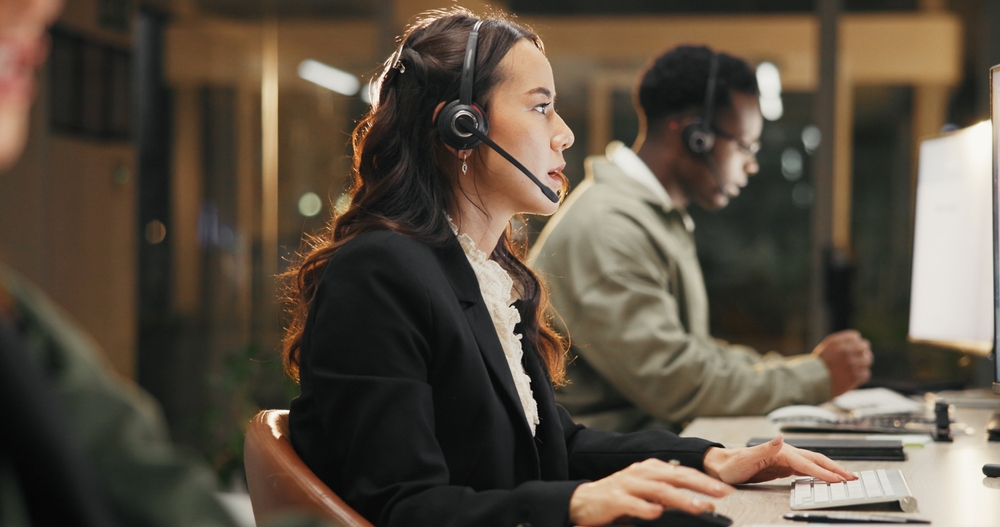 Woman,,Call,Center,And,Support,With,Headset,At,Night,For Professional office worker on a headset delivering responsive customer service with voip london ontario business phone solutions.