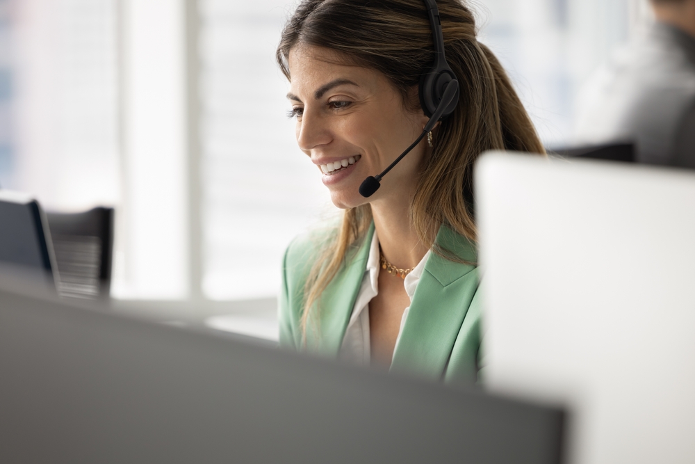Customer service professional wearing a headset while assisting clients using voip london ontario for business communications.