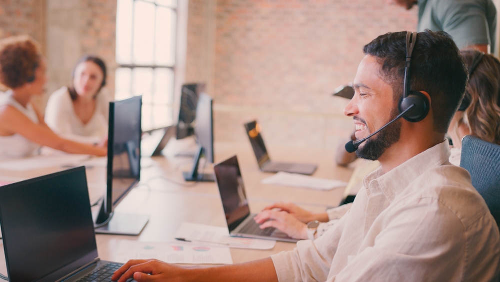 IT manager on a headset call reviewing options among VoIP service providers