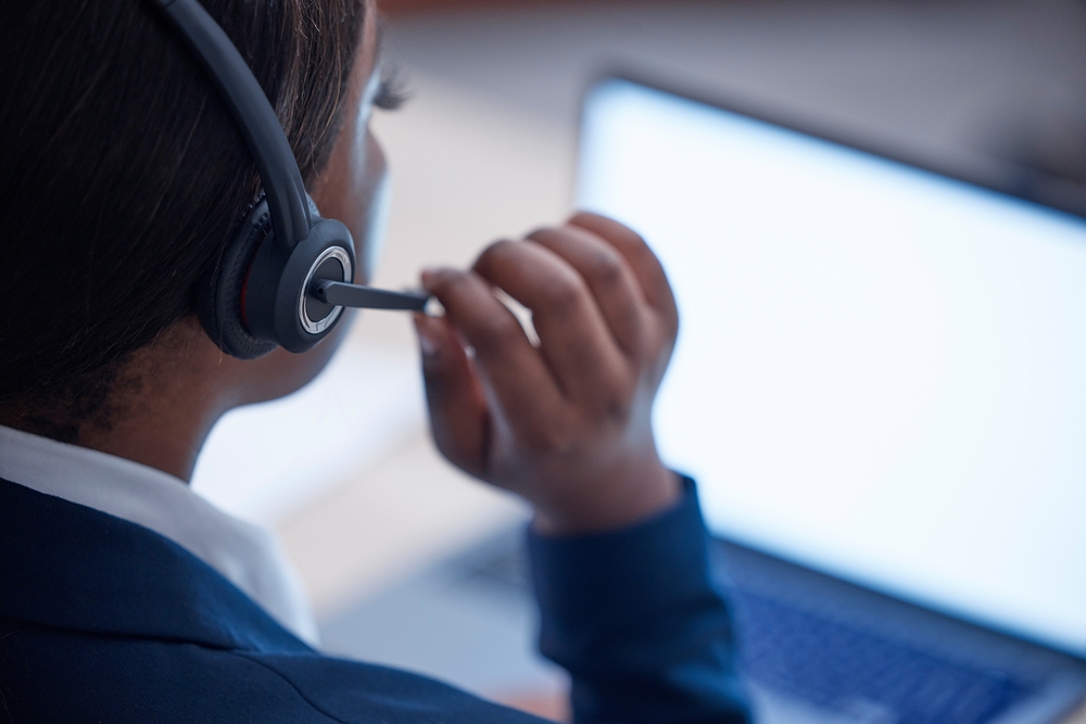 Office employee managing customer calls with a headset in a modern workplace powered by voip phone Vancouver business phone solutions.

