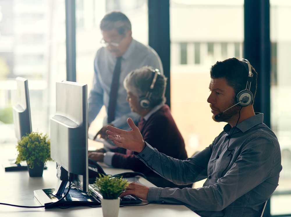 Business professional speaking with clients through a headset while using voip phone Vancouver for clear and dependable office communications.
