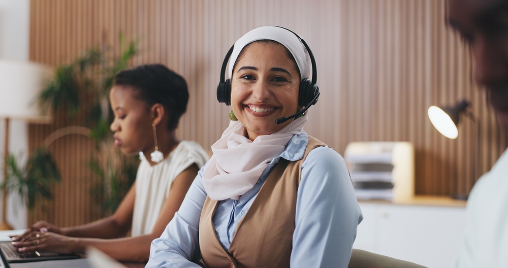 Customer service representative wearing a headset and using VoIP Solutions for Business in Niagara Falls for reliable communication.