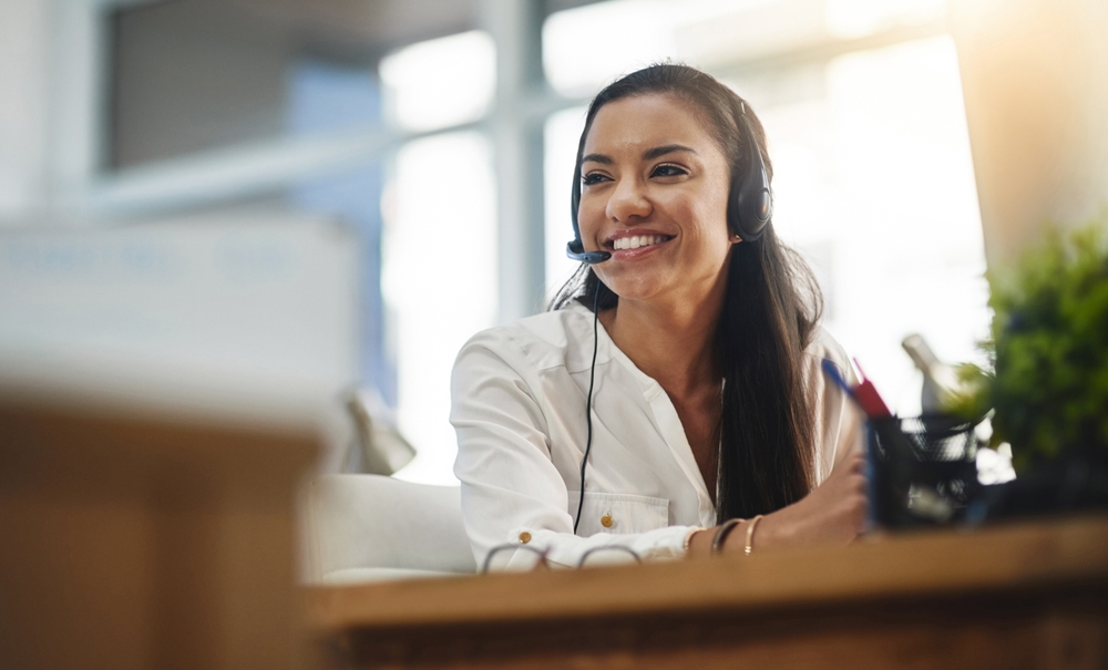 Business professional using a cloud communications platform through a headset at their desk