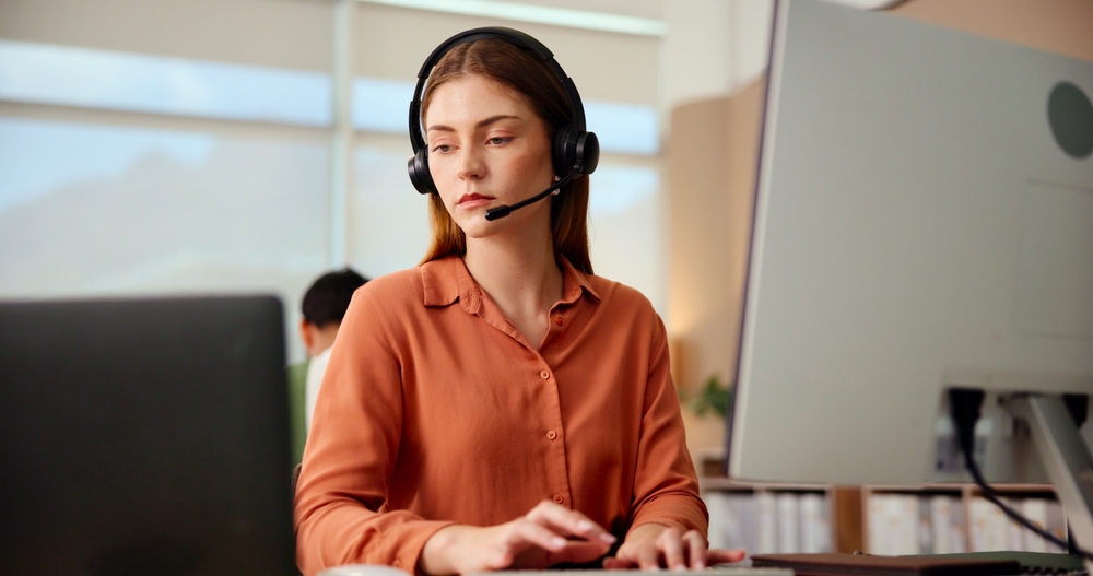Office employee talking on a headset over a stable connection backed by managed network services