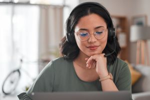 Professional wearing a headset taking a client call on a VoIP phone system at a modern office desk