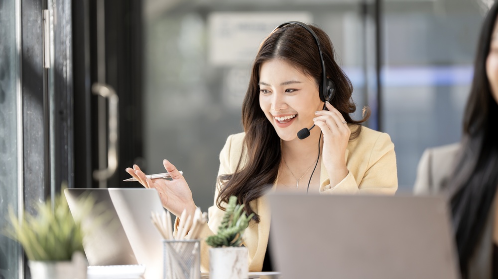 Customer service agent with a headset answering calls routed through a cloud business phone service