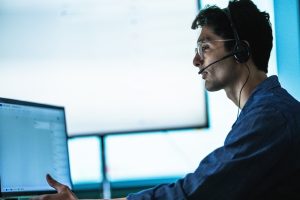 Office professional wearing a headset while taking a client call on an SE Telecom business phone service