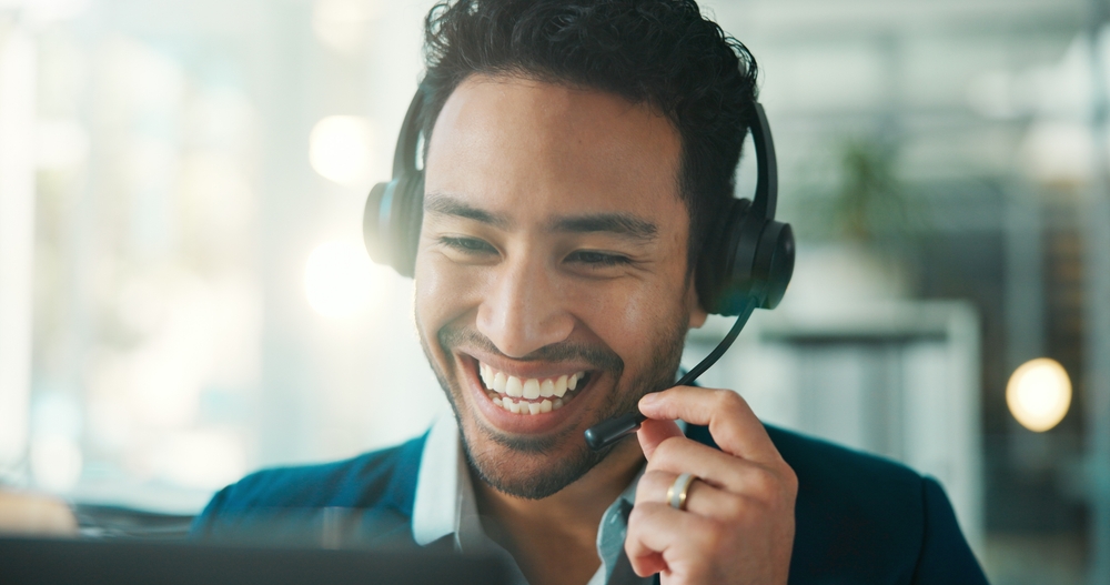 Office professional wearing a headset while answering a customer call on a hosted VoIP phone system
