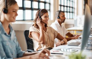 Smiling professional with a headset on a client call supported by SE Telecom hosted VoIP
